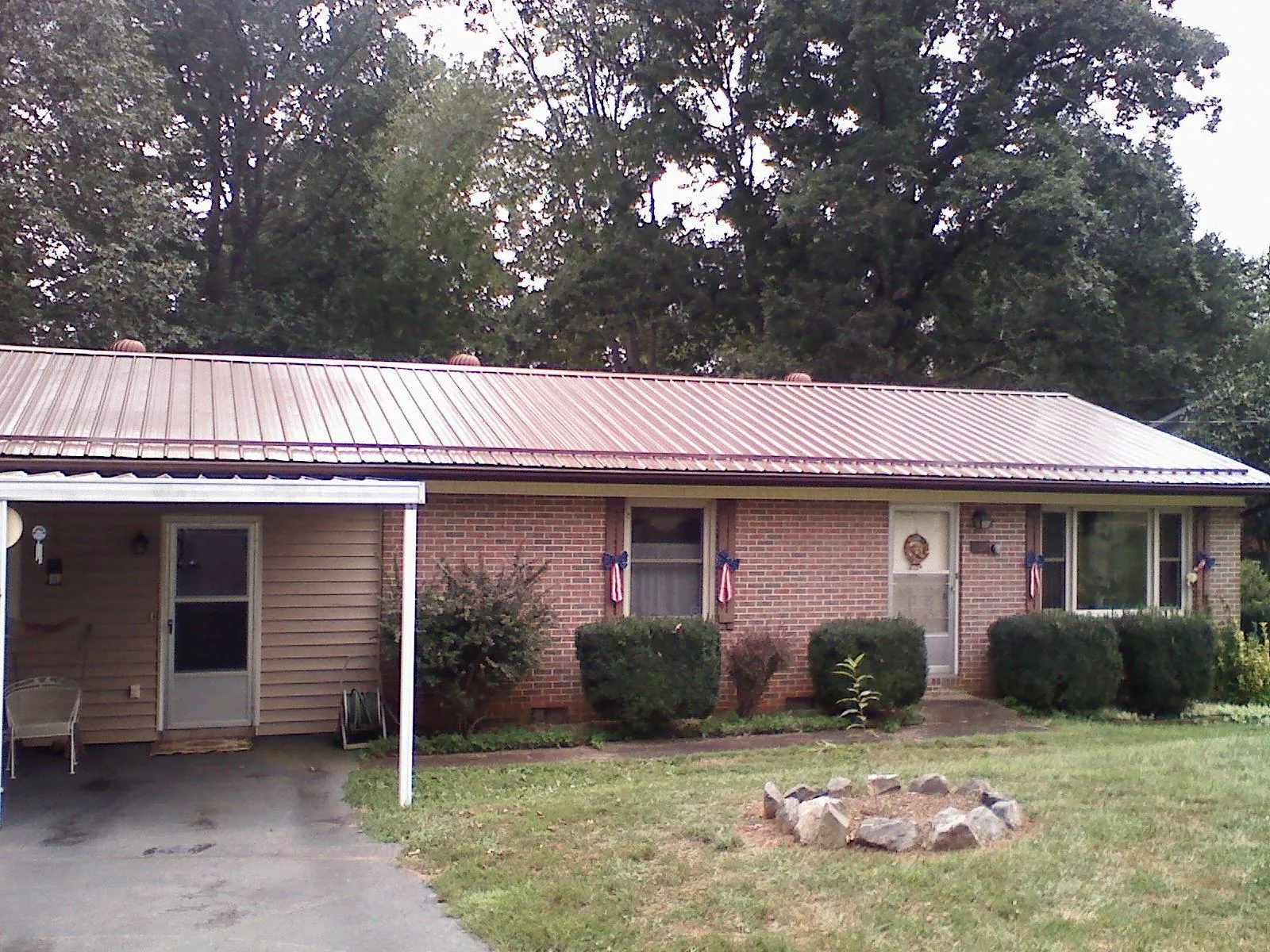 Bronze metal roof and carport on a brick ranch home — Roof Repair work by our crew in Buena Vista